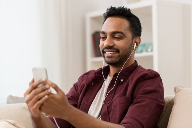 世界のマーケット市場規模「広告業界・PR業界ともに成長」 スマートフォンで音楽を聞く男性