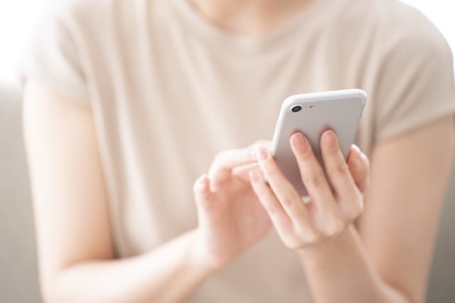 書評-バズる書き方〜書く力が、人もお金も引き寄せる(成毛眞:SB新書) スマホを操作する女性