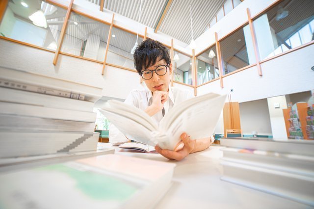 書評-バズる書き方〜書く力が、人もお金も引き寄せる(成毛眞:SB新書) 図書館で読書をする男性
